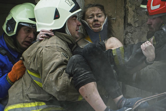 In this photo released by the State Emergency Service of Ukraine, firefighters carry a wounded woman out of the rubble of a building after a Russian rocket attack on Saturday in Dnipro.
