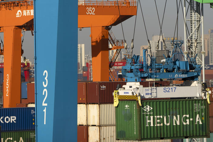 A crane lifts a shipping container at a container port in Tianjin, China, Monday, Jan. 16, 2023. China's economic growth fell to 3% last year under pressure from antivirus controls and a real estate slump.