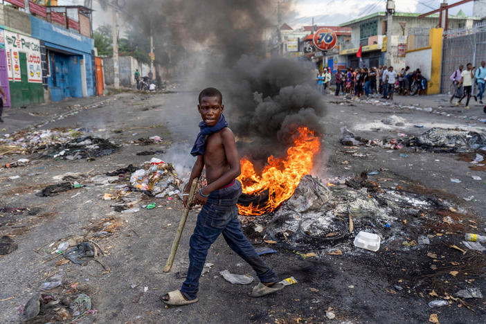 A man walks past a burning barricade during a protest against Haitian Prime Minister Ariel Henry, calling for his resignation, in Port-au-Prince.