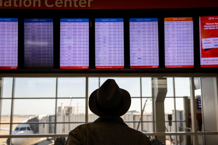 A passenger at Dallas-Fort Worth International Airport looks at a flight board after a system outage grounded thousands of flights throughout the country on Jan. 11.