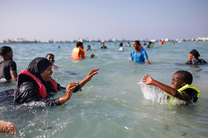 A mother and her son play in the sea at Liido Beach in Mogadishu, Somalia. Despite decades of conflict and ongoing security threats, some Somalis are carving out a middle-class lifestyle in the Somali capital.