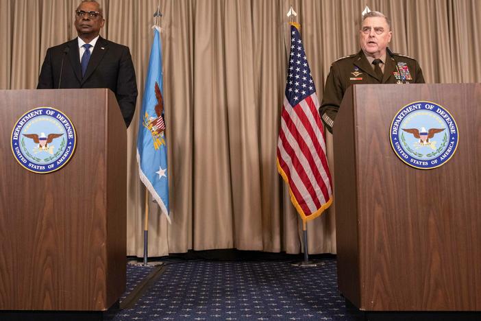 U.S. Defense Secretary Lloyd Austin (left) and the chairman of the Joint Chiefs of Staff, Gen. Mark Milley, discuss details of a huge U.S. and NATO arms package for Ukraine at the U.S. air base in Ramstein, Germany, on Friday.