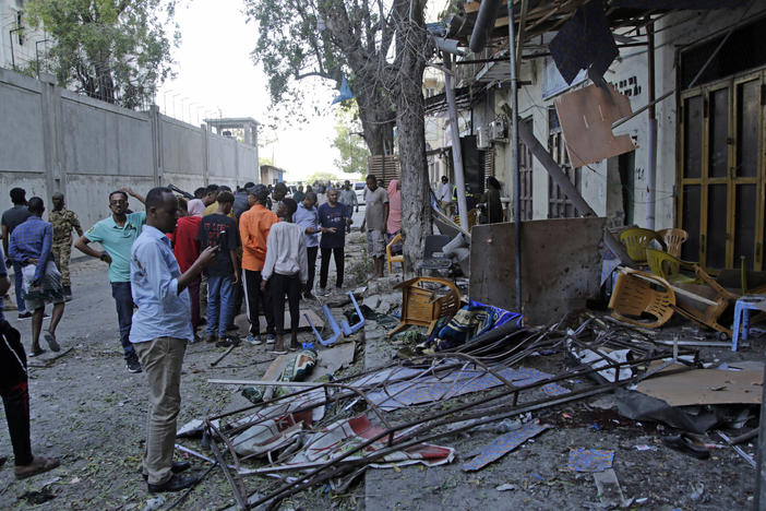People gather outside their destroyed shops after a suicide bomber detonated at the Banadir regional administration in Mogadishu on Sunday.