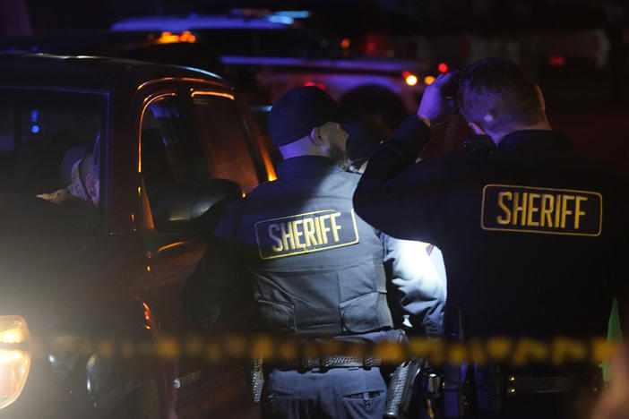 Law enforcement personnel stand at the scene of a shooting on Monday in Half Moon Bay, Calif. Seven people were killed in two related shootings.