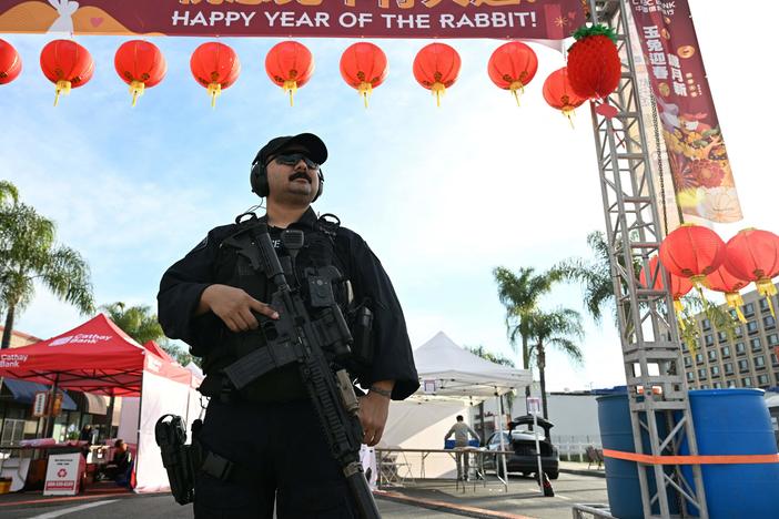 Monterey Park police officers stand at the scene of a mass shooting in Monterey Park, California.