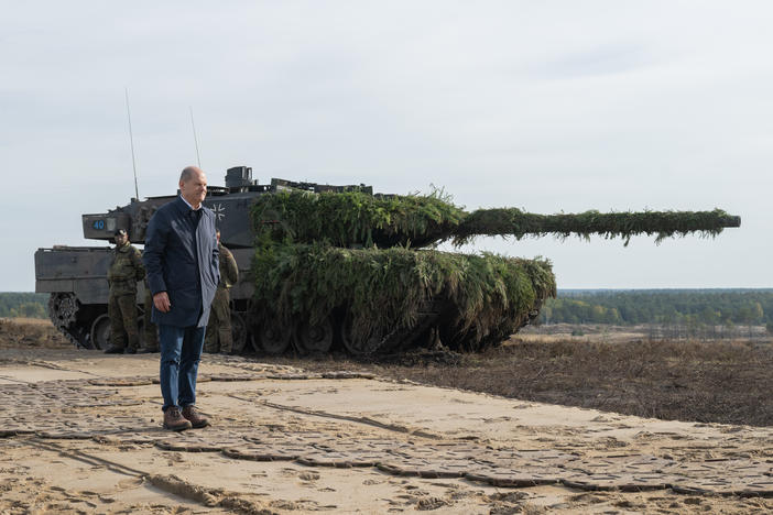 German Chancellor Olaf Scholz stands next to a Leopard 2 main battle tank of the German armed forces while visiting an army training center in Ostenholz, Germany, on Oct. 17, 2022.
