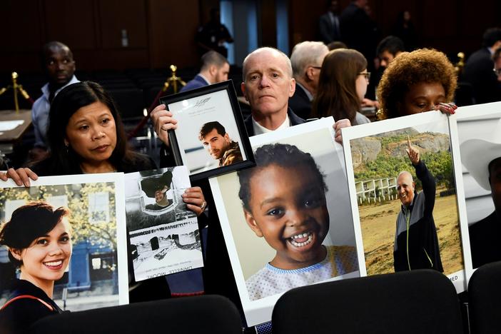 People holding photos of those lost in Ethiopian Airlines Flight 302 and Lion Air Flight 610 wait for the start of a Senate Committee on Commerce, Science, and Transportation hearing on Capitol Hill in Washington, D.C., Tuesday, Oct. 29, 2019, about "Aviation Safety and the Future of Boeing's 737 MAX."