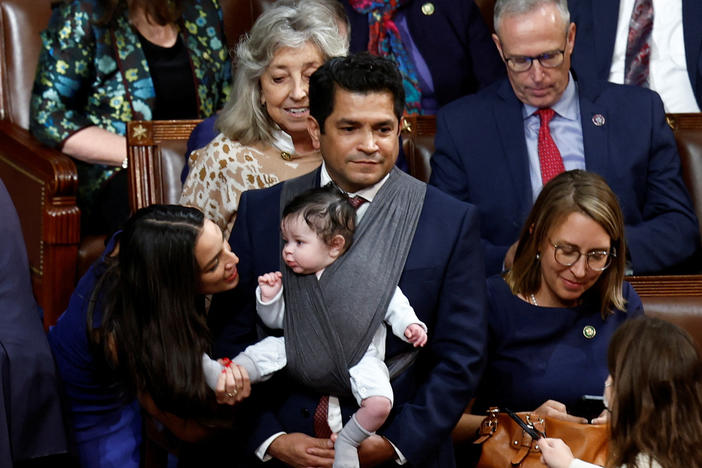 U.S. Rep. Alexandria Ocasio-Cortez, D-N.Y., talks to the infant child of Rep. Jimmy Gomez, D-Calif., inside the House chamber during votes for the next speaker of the House on the first day of the 118th Congress at the U.S. Capitol in Washington, D.C., on Jan. 3.