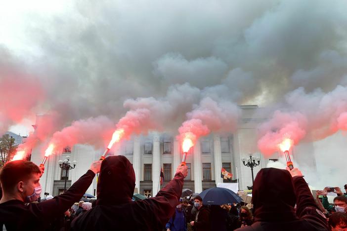 Demonstrators burn flares and smoke bombs outside the Ukrainian parliament in Kyiv on June 5, 2020, during a demonstration calling for the interior minister's resignation over corruption suspicion.