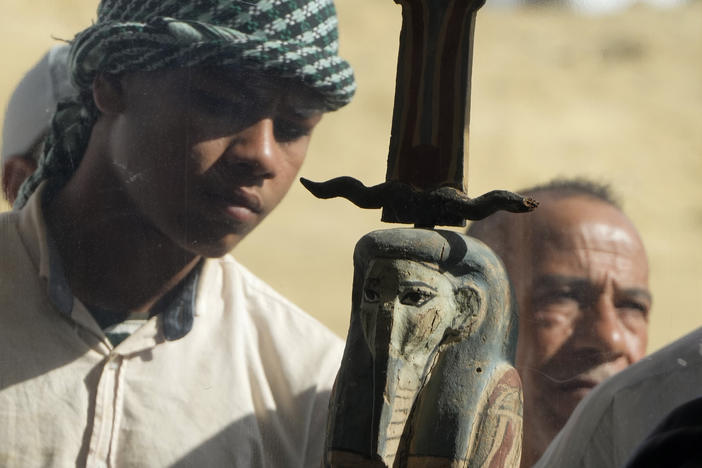 An Egyptian antiquities worker watches a recently discovered artifact at the site of the Step Pyramid of Djoser in Saqqara, 24 kilometers (15 miles) southwest of Cairo, Egypt, Thursday, Jan. 26, 2023.