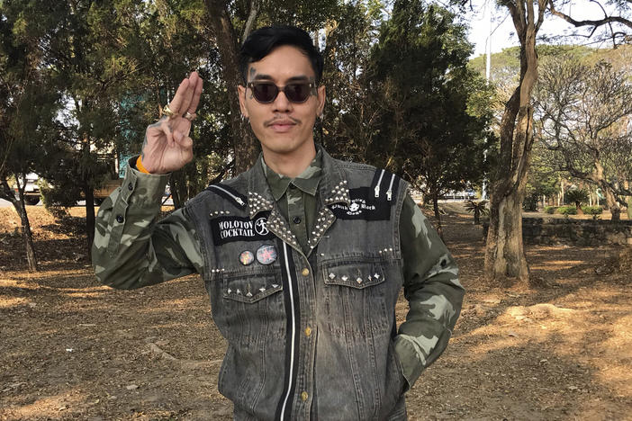 Political activist Mongkhon Thirakot flashes the pro-democracy gesture of a three-finger salute ahead of going to a court in Thailand's northern province of Chiang Rai, Thailand, Thursday Jan. 26, 2023.