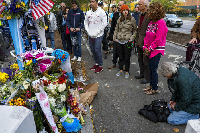 A group pauses in 2017, with some in prayer, at a makeshift memorial on a New York City bike path that that honors victims of an attack who were stuck and killed by a rental truck driven by Sayfullo Saipov. The Islamic extremist was convicted of federal crimes on Thursday and could face the death penalty.