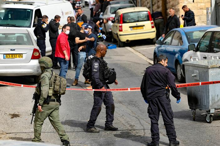 Israeli security forces and emergency service personnel gather at a cordoned-off area in Jerusalem's predominantly Arab neighborhood of Silwan, where police say an assailant shot and wounded two people on Saturday.