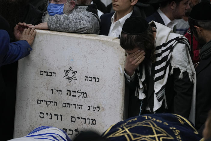 Mourners gather around the bodies of Israeli couple Eli Mizrahi and his wife, Natalie, victims of a shooting attack Friday in east Jerusalem, during their funeral at the cemetery in Beit Shemesh, Israel, early Sunday, Jan. 29, 2023.