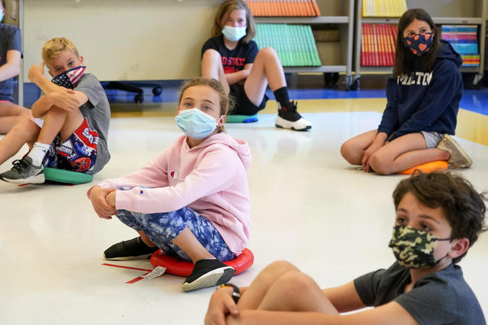Fifth-graders wearing face masks sit at proper social distancing during a music class at the Milton Elementary School in Rye, N.Y., May 18, 2021. The COVID-19 pandemic that shuttered classrooms set back learning in some U.S. school systems by more than a year, with children in high-poverty areas affected the most, according to data shared with The Associated Press.