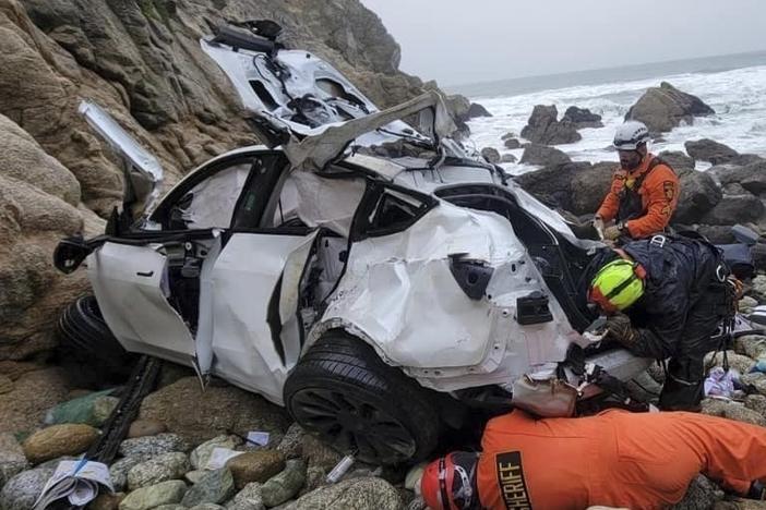 Emergency personnel respond to a vehicle over the side of Highway 1 on Jan. 1, 2023, in California's San Mateo County. The driver who plunged off the treacherous cliff, seriously injuring himself, his wife and their two young children, has been charged with attempted murder.