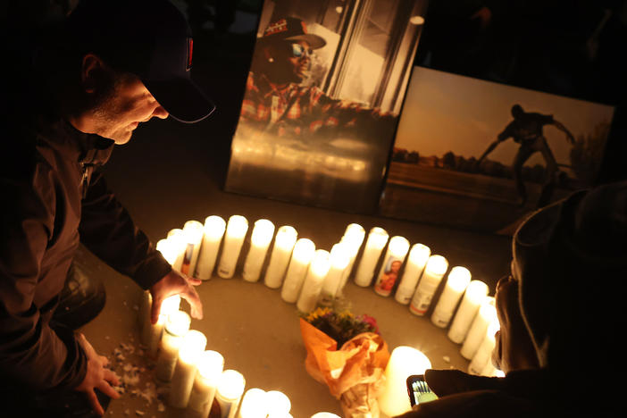 A mourner sits next to a candle display during a vigil for Tyre Nichols on Jan. 30 at Regency Community Skatepark in Sacramento, Calif. Nichols was an avid skateboarder and used to frequent the park.