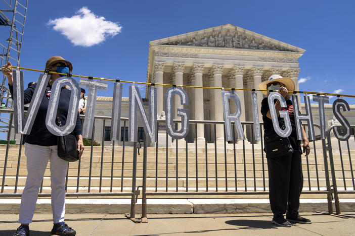 Demonstrators hold up large cut-out letters spelling "VOTING RIGHTS" at a 2021 rally outside the U.S. Supreme Court in Washington, D.C.