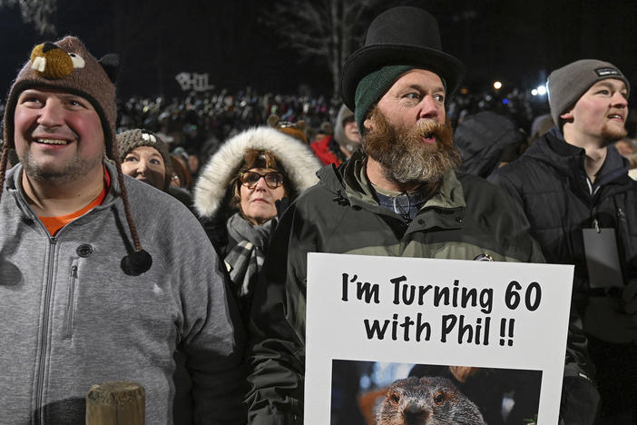 Rory Szwed, left, and Kent Rowan watch the festivities while waiting for Punxsutawney Phil to make his prediction at Gobbler's Knob in Punxsutawney, Pa., early Thursday morning.