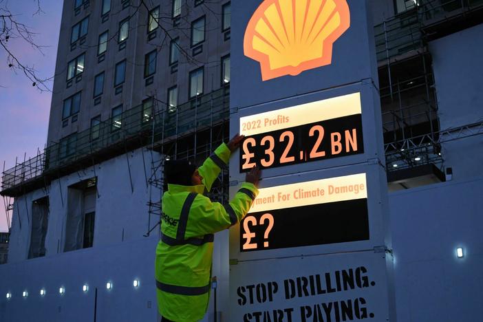 Activists from Greenpeace set up a mock-petrol station price board displaying the Shell's net profit for 2022.