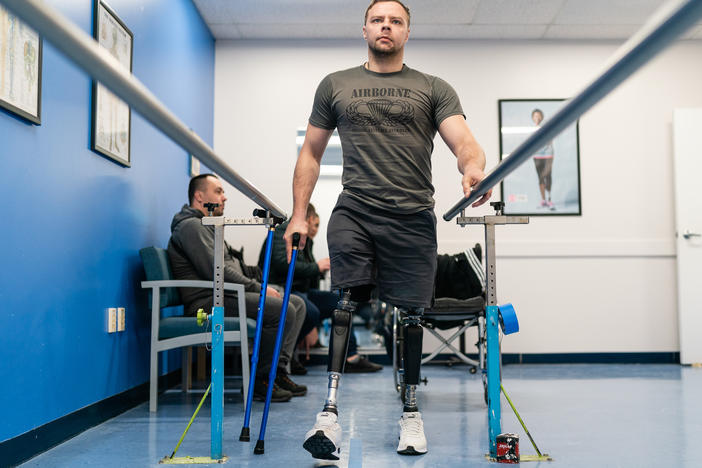 Oleksandr Fedun, 24, holds onto railings as he practices walking on his prostheses at Medical Center Orthotics & Prosthetics (MCOP) in Silver Spring, Md., on Thursday. MCOP is working with several charities and organizations to help fit Ukrainian soldiers with prostheses after they've been injured in combat.
