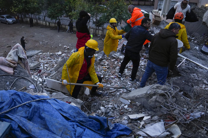 Emergency team members search for people in a destroyed building in Adana, Turkey on Monday.