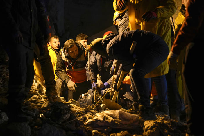 Emergency teams search in the rubble for people in a destroyed building in Adana, Turkey, on Monday.