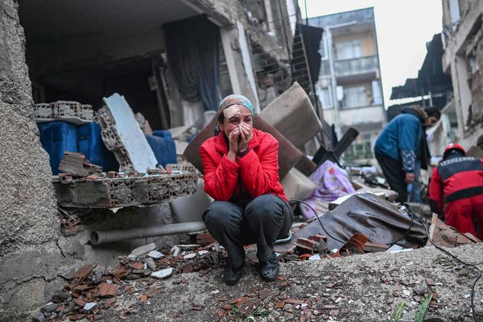 An earthquake survivor reacts as rescuers look for victims and other survivors in Hatay, the day after a 7.8-magnitude earthquake struck the country's southeast on February 7, 2023.