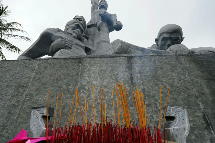 Incense sticks are placed at a monument to honor massacre victims in Vietnam.