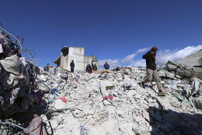 People search through the rubble of collapsed buildings in the town of Jinderis, Aleppo province, Syria, Tuesday.