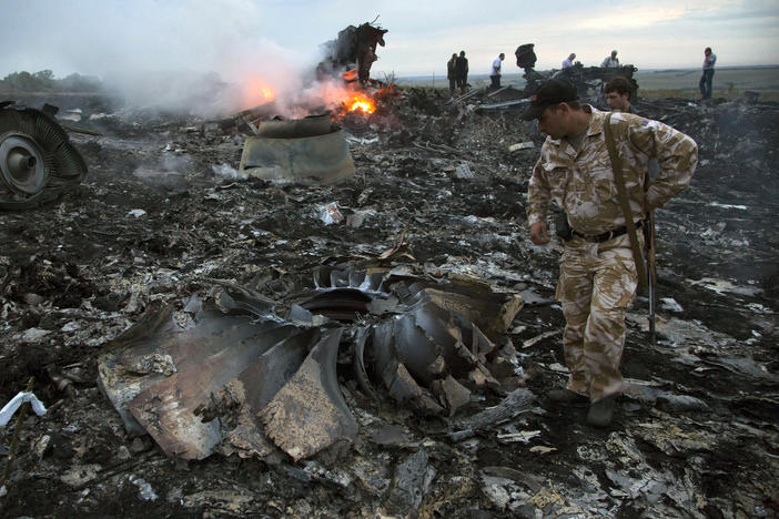 People walk among the debris at the crash site of Malaysia Airlines flight MH17 near the village of Grabovo, Ukraine, on July 17, 2014. All 298 people on board were killed.