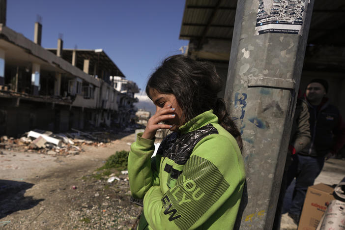 A girl stands next to destroyed buildings in Antakya, southern Turkey on Wednesday.