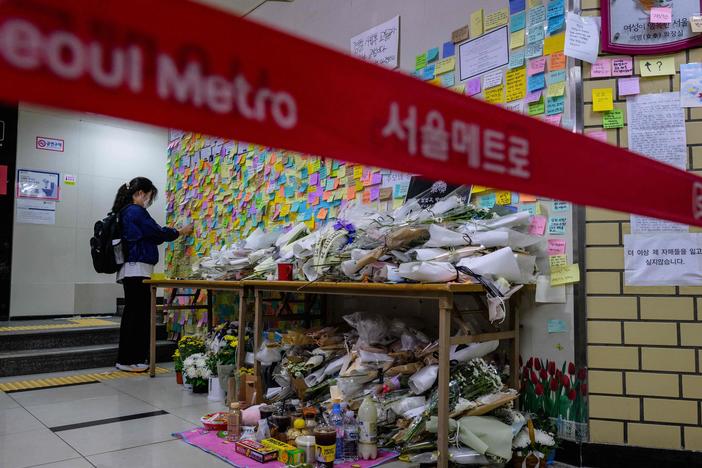 A woman pays her respects as she displays a note near the entrance to a female lavatory at Sindang station in Seoul on Sept. 19, 2022. Seoul Metro employee Jeon Joo-hwan was sentenced Tuesday for stabbing his colleague to death in the metro station's women's public toilet the day before a court was set to sentence him on charges of stalking her.