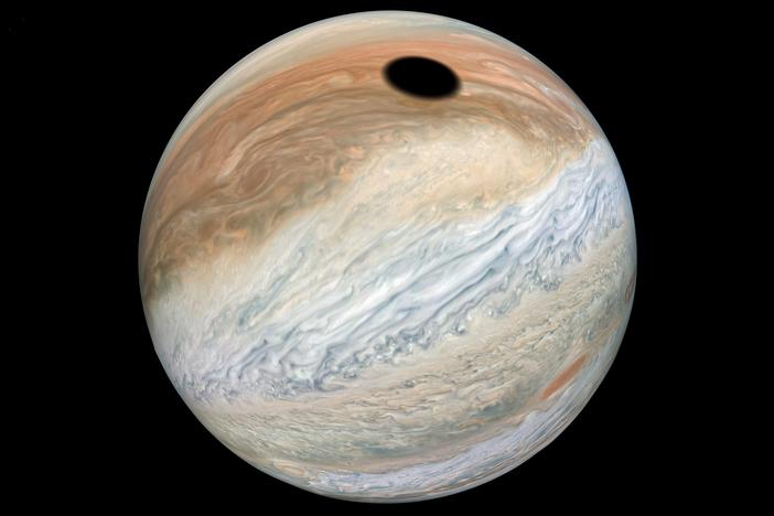 This composite was made with images from NASA's Juno mission and shows the shadow on Jupiter cast by Io, one of its many moons.