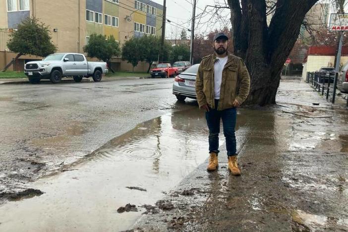 Antonio López, East Palo Alto's vice mayor, stands next to floodwaters in the city.