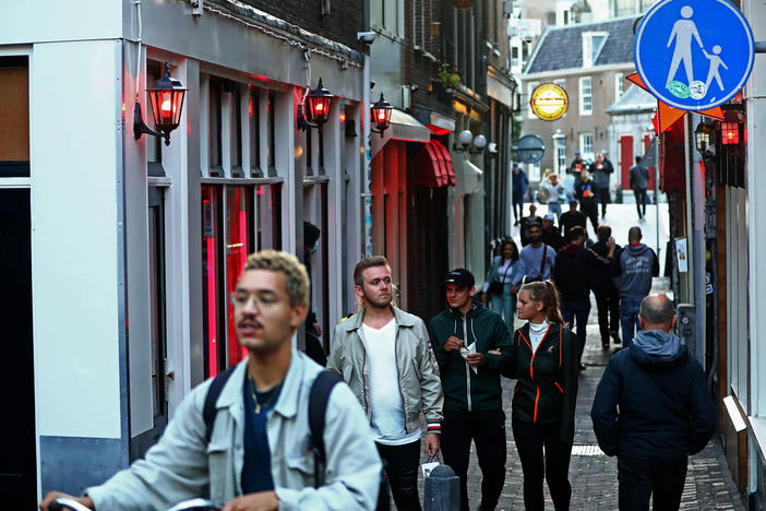 People walk through Amsterdam's red-light district shortly after it reopened in 2020, during the pandemic. The neighborhood attracts millions of tourists each year.