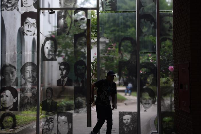 A visitor enters the Officers Casino building at ESMA on March 19, 2016. The windows are filled with images of civilians who were tortured and killed here.
