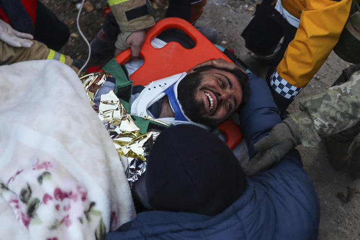 Turkish rescue workers carry Ergin Guzeloglan, 36, to an ambulance on Saturday after pulling him out of a collapsed building in Hatay, southern Turkey, five days after an earthquake devastated the region.