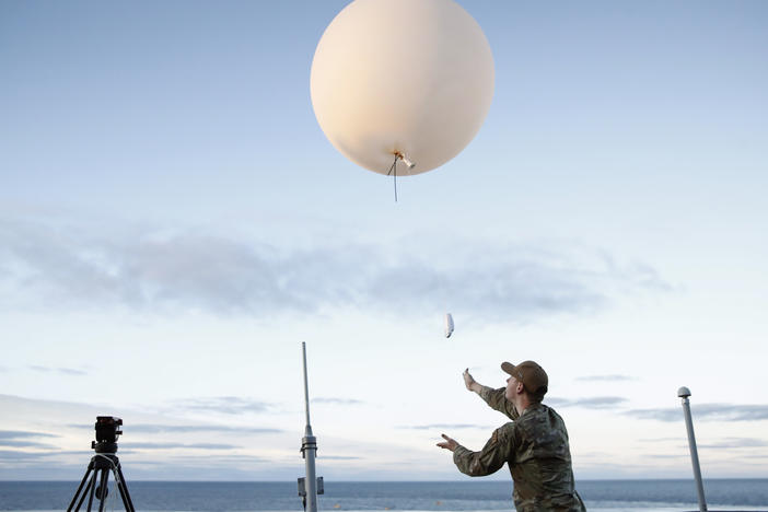 A U.S. Air Force member releases a weather balloon from the deck of the U.S.S. Portland off the coast of Baja California, Mexico, in December 2022.