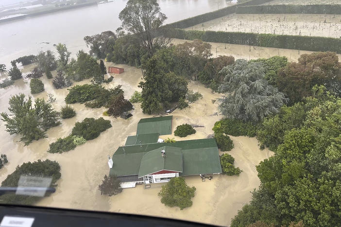 In this image released by the New Zealand Defense Force on Wednesday, Feb. 15, people stand on a rooftop of a home waiting to be winched to safety by helicopter in the Esk Valley, near Napier, New Zealand. The government declared a national state of emergency Tuesday after Cyclone Gabrielle battered the country's north in what officials described as the nation's most severe weather event in years.