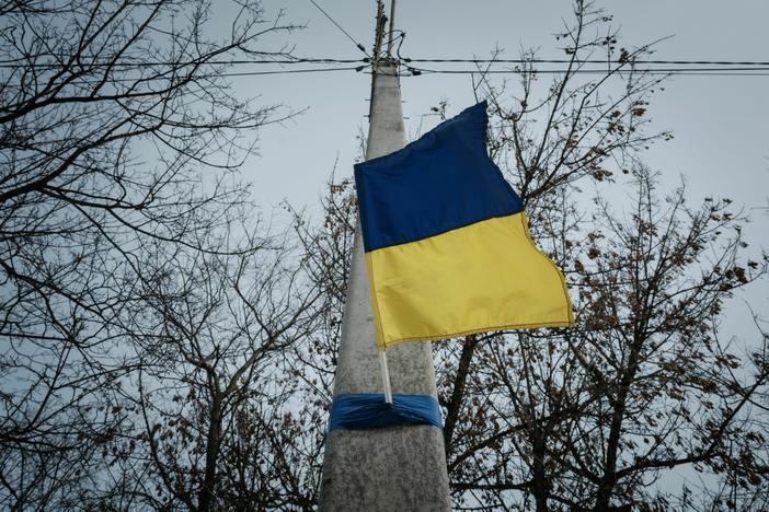 A Ukrainian flag adorns an electrical post in Kupiansk, in the Kharkiv region, on Feb. 13, nearly a year after the Russian invasion of Ukraine.