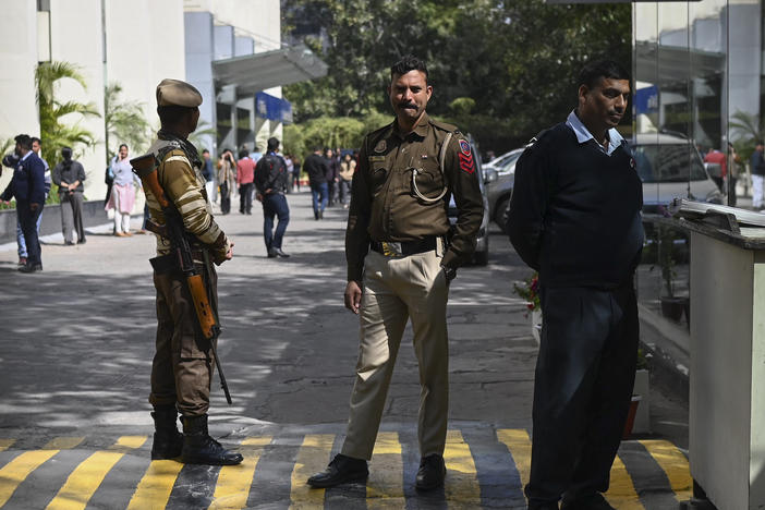 A police officer stands at the entrance of the office building where Indian tax authorities raided BBC's office in New Delhi on Tuesday.