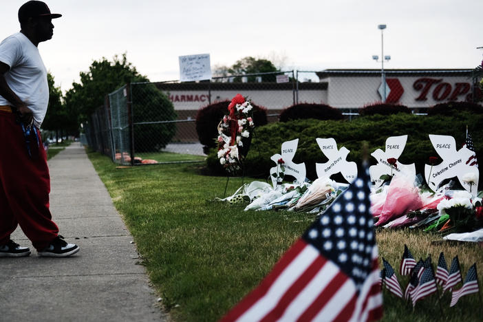 A person stands at a memorial for the victims of the May 2022 shooting at a Tops supermarket in Buffalo, N.Y.