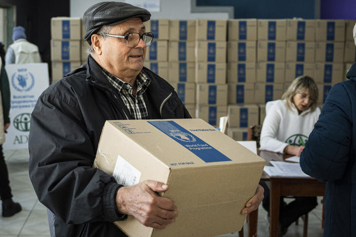 A man receives humanitarian aid provided by U.N. World Food Program and ADRA charity organization for the residents of the region and internally displaced persons at the distribution center in Kostiantynivka, Ukraine, Friday, Feb. 10, 2023.