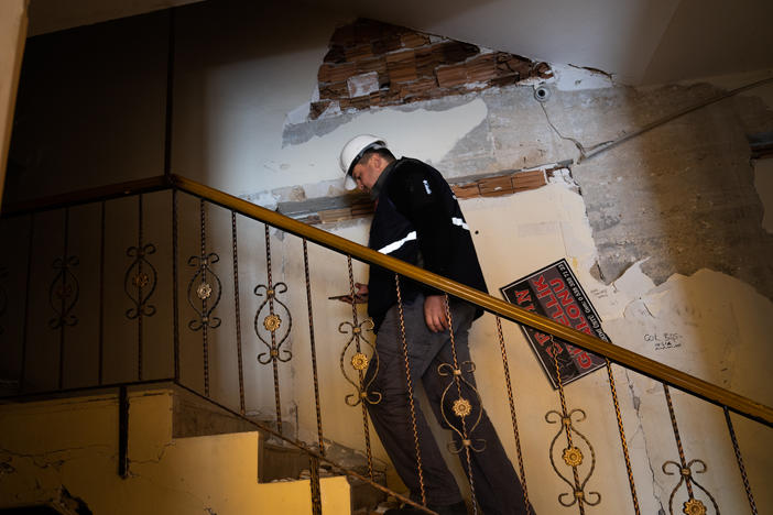 Yasin Pinarbasi walks into a building he inspected that suffered some earthquake damage, west of Antakya, Turkey.