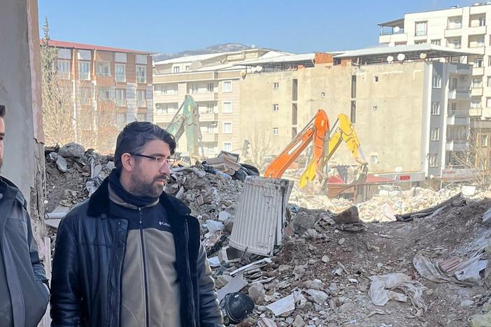 Ali Kafadenk (left) and his brother, Abdullah, look at the rubble of Ali's apartment in Islahiye, Turkey. Ali and his wife MerveÂ survived the earthquake Feb 6.