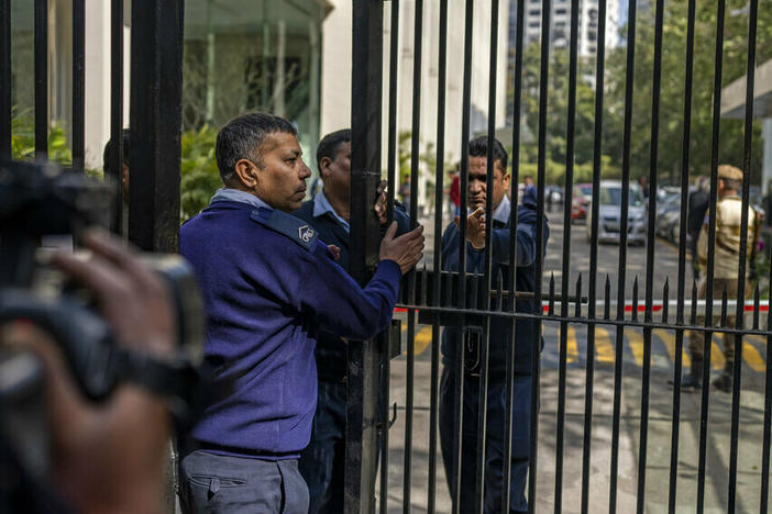 Private security guards close the gate of a building housing BBC office in New Delhi, India.