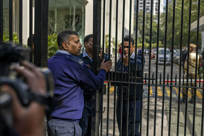Private security guards close the gate of a building housing BBC office in New Delhi, India.