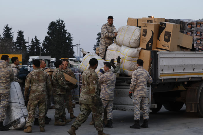 Troops load aid onto a vehicle as U.S. Secretary of State Antony Blinken visits Incirlik Air Base near Adana, Turkey, on Sunday.