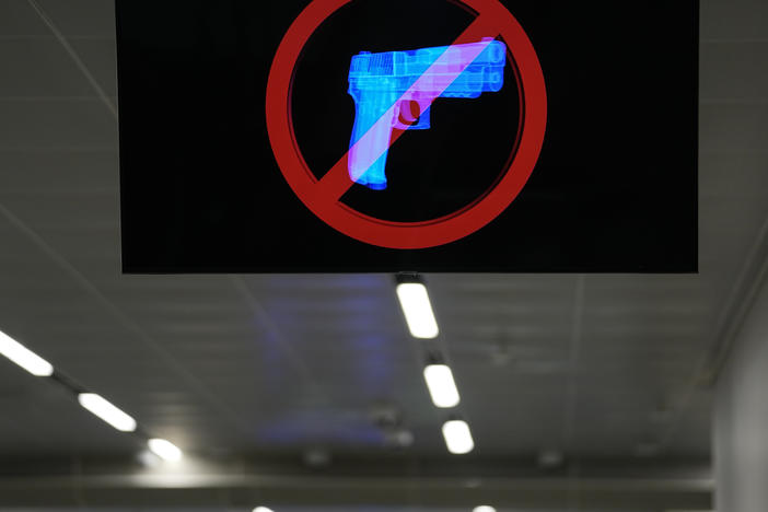 A television displays a "no guns" sign at the Transportation Security Administration security area at the Hartsfield-Jackson Atlanta International Airport on Wednesday, Jan. 25, 2023, in Atlanta. Last year saw a record number of guns intercepted at airport checkpoints across the country.